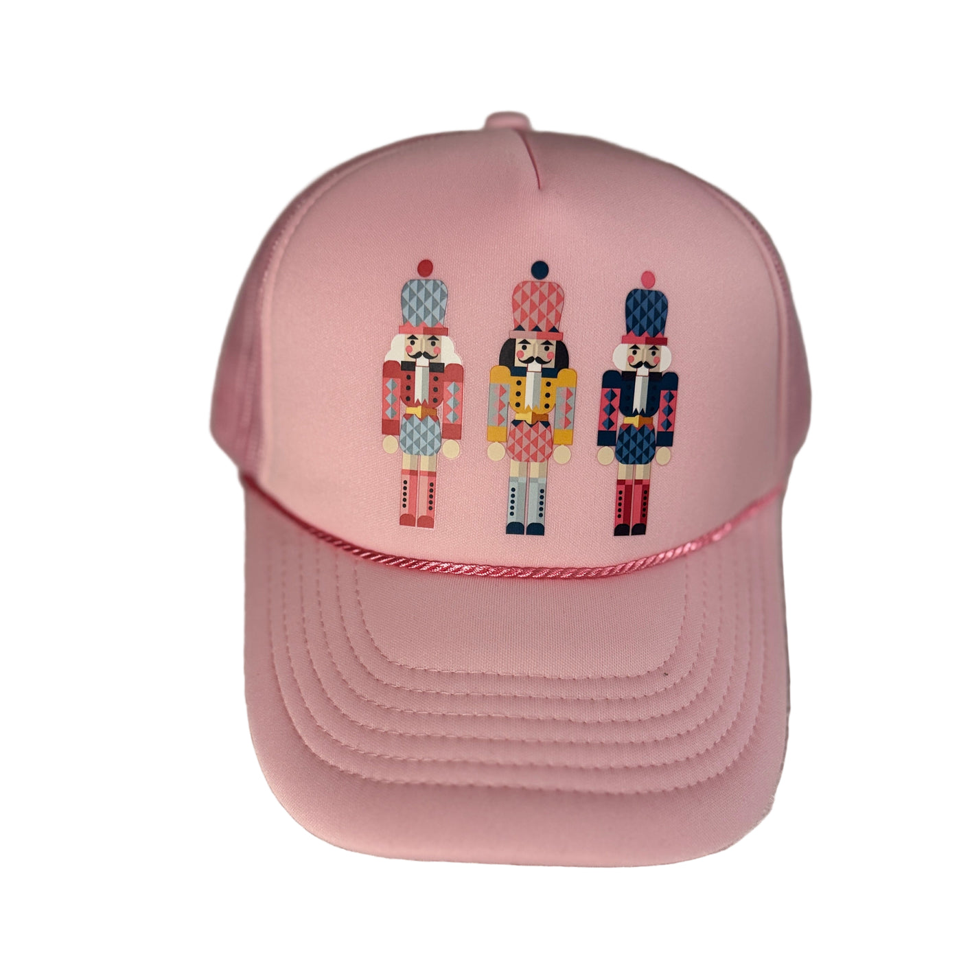 Pink cap with embroidered nutcracker designs on a textured surface